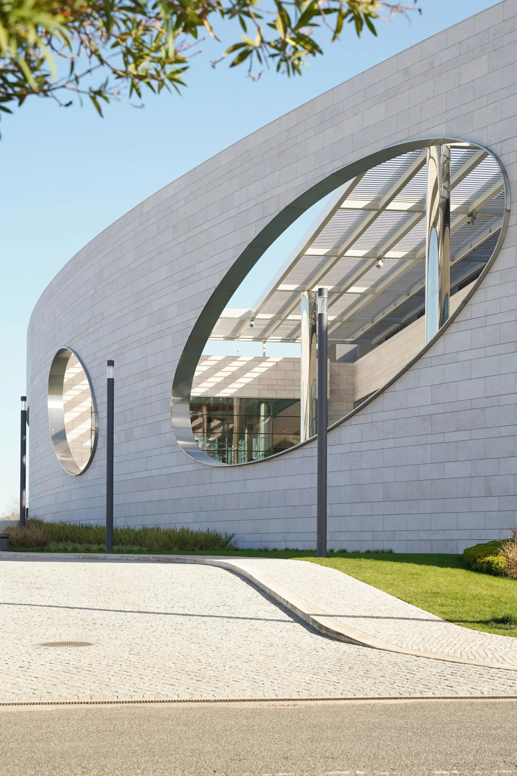 Modern curved building with oval glass reflections, symbolizing origin and intentional design by ORIGIN SWISS