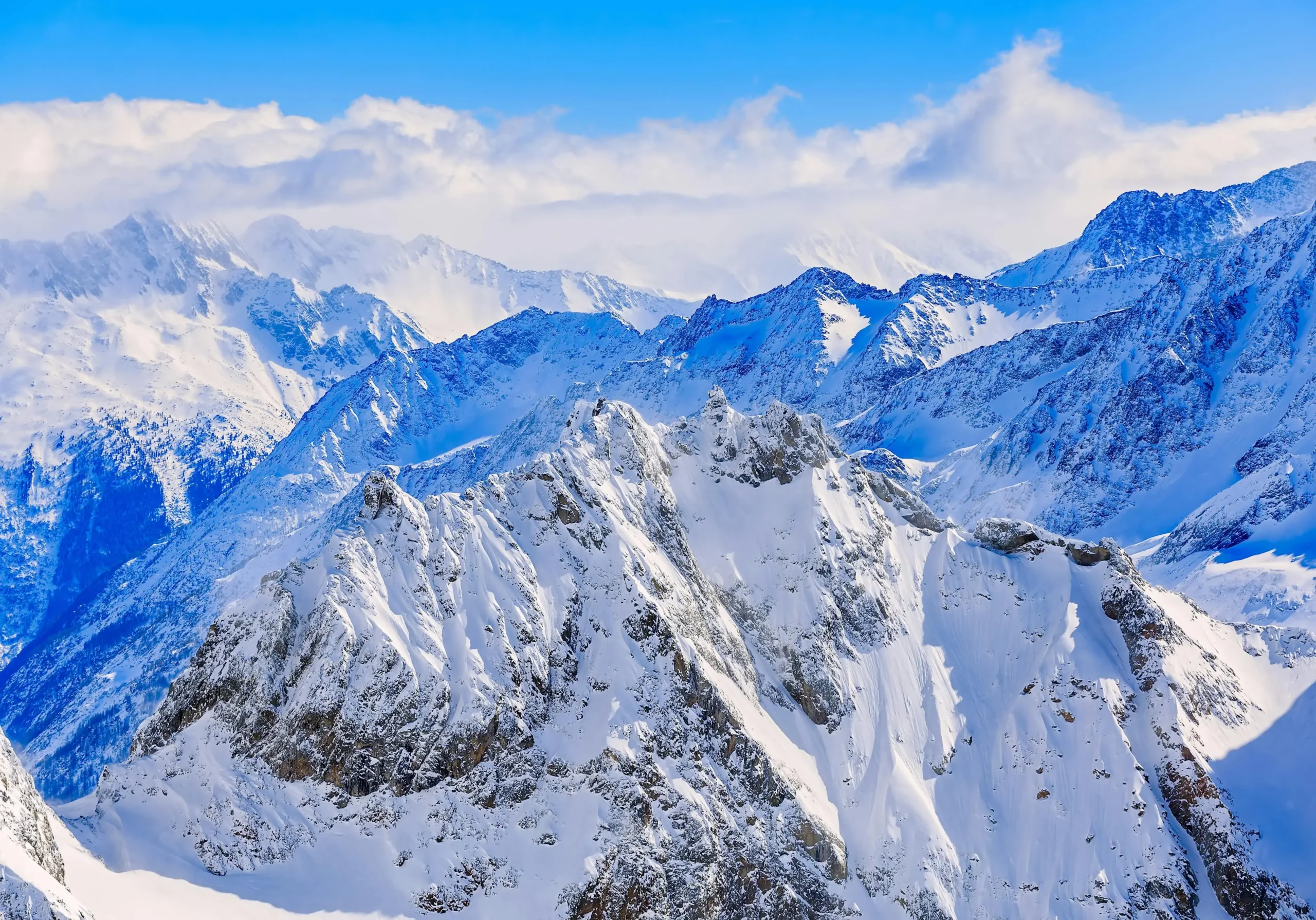 Snow-covered alpine peaks under blue sky symbolizing strategic clarity and elevation at ORIGIN SWISS